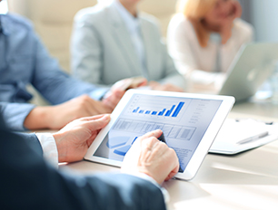 Cropped shot of a group of businesspeople looking at graphs on digital tablets